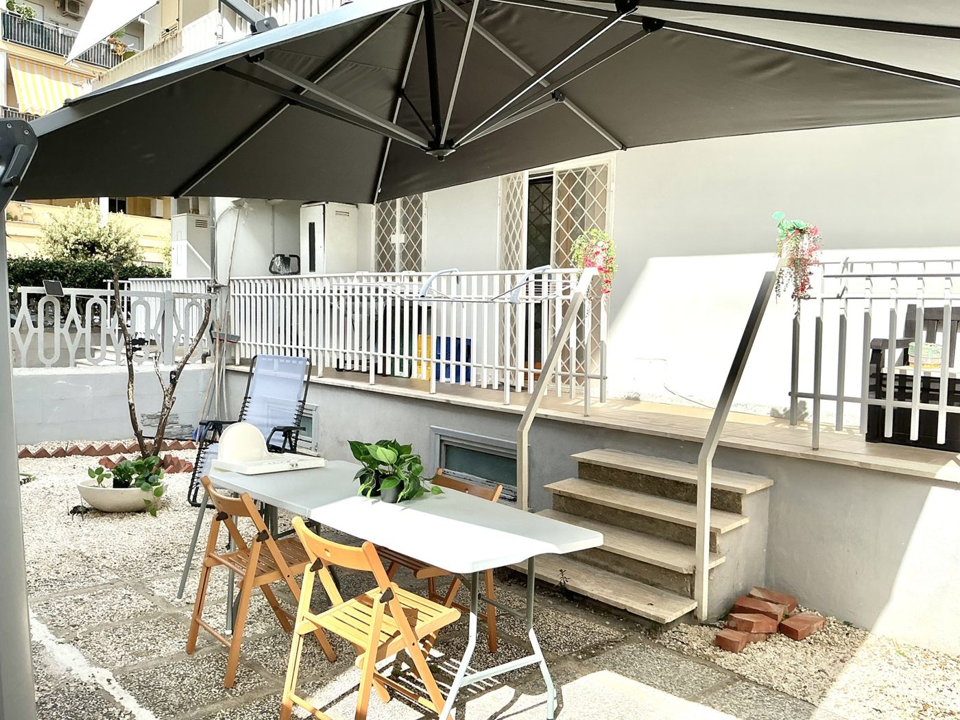 The private garden with parasol and table of the Garden Apartment in Santa Marinella
