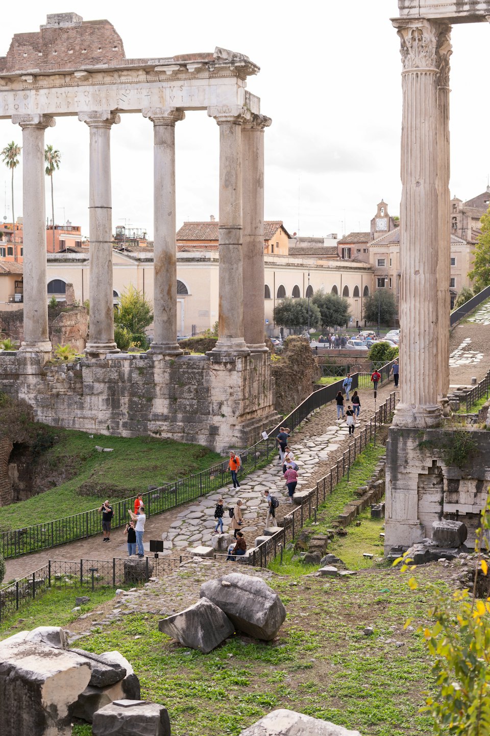 Turisti passeggiano lungo un sentiero tra le rovine di un antico tempio romano.